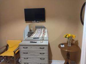 a bedroom with a bed and a dresser with a mirror at Bee happy in Agioi Apostoli