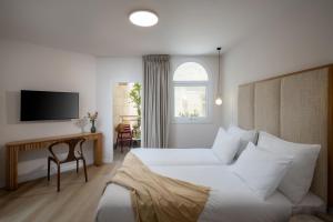 a hotel room with a bed and a television at Naveh Tamar - Mehadrin Kosher suitable for Ultra-Orthodox guests in Acre