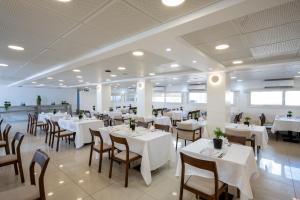 a dining room with white tables and chairs at Naveh Tamar - Mehadrin Kosher suitable for Ultra-Orthodox guests in Acre