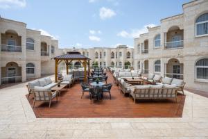 a large patio with chairs and tables in front of a building at Naveh Tamar - Mehadrin Kosher suitable for Ultra-Orthodox guests in Acre
