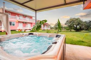 a hot tub on the patio of a house at Riposo Studios & Apartments in Kavos