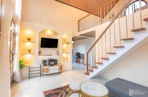 a living room with a staircase and a tv at Umacabana 2 in Diyeng