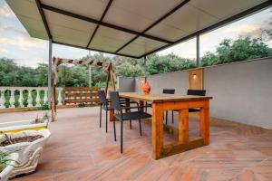 a patio with a wooden table and chairs on a deck at Riposo Studios & Apartments in Kavos