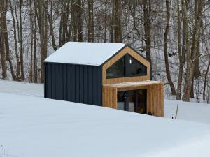 a smallshed with snow on the ground at Wilcza Osada Wellness Resort in Wilcza