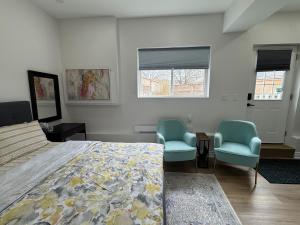 a bedroom with two blue chairs and a bed at Home away from home! in Pickering