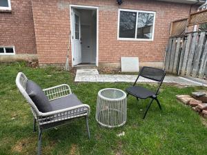 a yard with two chairs and a table and a grill at Home away from home! in Pickering