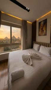 a bedroom with a large white bed with a large window at Pyramids Sunshine View in Giza +284 photos