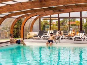 a group of people sitting in a swimming pool at Mercure Cabourg Hôtel & Spa in Cabourg