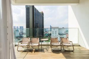 a balcony with chairs and a table and a view of a city at Veone Hotel Kuala Lumpur in Kuala Lumpur