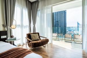 a bedroom with a bed and a chair and a large window at Veone Hotel Kuala Lumpur in Kuala Lumpur +289 photos