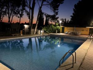 a swimming pool at night with the lights on at Casica de Hellín in Hellín