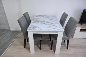 a white table with four chairs around it at Apartman biserna Sofija in Topola +7 photos