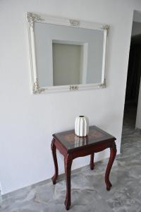 a table with a mirror on a white wall at Apartman biserna Sofija in Topola