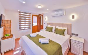 a bedroom with a large white bed with green pillows at Kaşhan Otel in Kaş