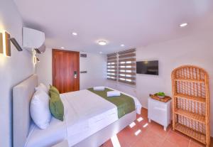 a bedroom with a white bed and a television at Kaşhan Otel in Kaş