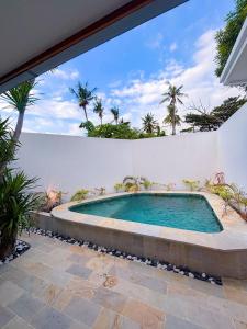 a swimming pool in the backyard of a house at Ajolie Villa in Gili Islands