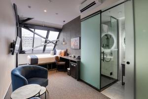 a hotel room with a bed and a bathroom at The Viv Hotel Wellington in Wellington