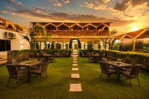 a patio with tables and chairs in front of a building at Hotel Happy Forest -Boutique Garden Retreat in Mount Abu in Mount Ābu