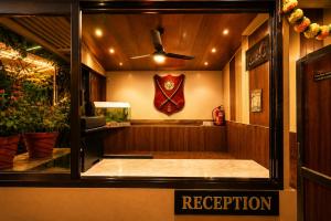 a room with a window with a red regurrection sign at Hotel Happy Forest -Boutique Garden Retreat in Mount Abu in Mount Ābu