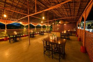 a room with tables and chairs in a building at Hotel Happy Forest -Boutique Garden Retreat in Mount Abu in Mount Ābu