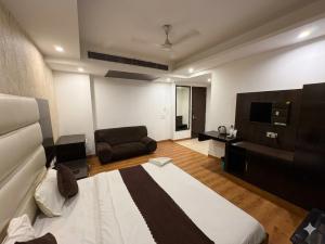 a living room with a bed and a couch at Hotel Rajpath Residency 2 Min Walk From Kaushambhi Metro Station in Ghaziabad +29 photos