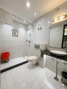 a white bathroom with a toilet and a sink at Hotel Rajpath Residency 2 Min Walk From Kaushambhi Metro Station in Ghaziabad