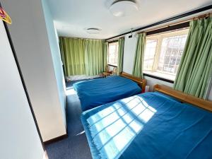 a bedroom with two beds and a window at 自遊人の宿 in Odawara