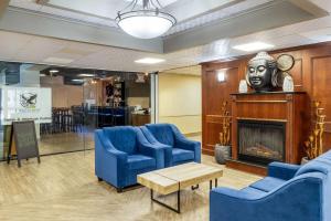 a waiting room with blue chairs and a fireplace at Days Inn by Wyndham Sudbury & Conference Centre in Sudbury
