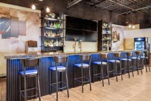 a bar with blue stools in a room at Days Inn by Wyndham Sudbury & Conference Centre in Sudbury