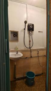 a bathroom with a sink and a hair dryer at AKI Backpackers in Ranau