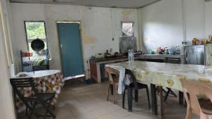 a kitchen with a table and some chairs in a room at AKI Backpackers in Ranau +36 photos