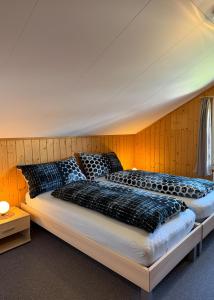 a bedroom with two beds with black pillows at Chalet Bim Chilchli in Mürren
