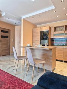 a kitchen with a counter and two chairs in a room at Makowy Apartament in Milicz