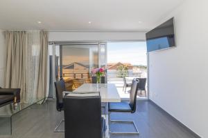 a dining room with a white table and chairs at Villa Kovac in Zadar