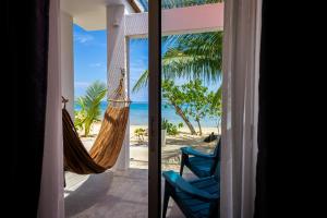 a room with a hammock and a view of the beach at Coral Reef Holidays in Tioman Island