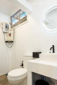 a white bathroom with a toilet and a sink at Coral Reef Holidays in Tioman Island +37 photos