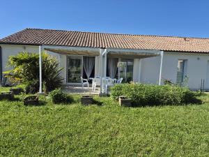 a white house with a table and chairs in the yard at Justine's house in Alvignac in Alvignac