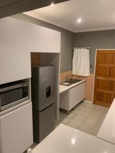 a kitchen with a stainless steel refrigerator and a sink at The Residence at 1907 in Thulamahashi