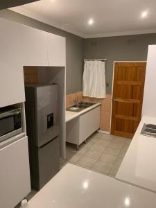 a kitchen with a sink and a refrigerator at The Residence at 1907 in Thulamahashi +9 photos