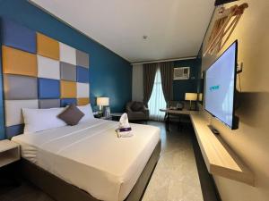 ein Hotelzimmer mit Bett und Flachbildfernseher in der Unterkunft Yes Hotel Pandi Bulacan in Pandi