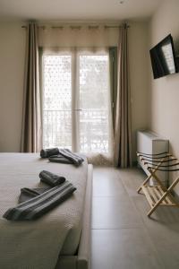 a bedroom with a bed and a large window at Karamelaki in Pythagoreio