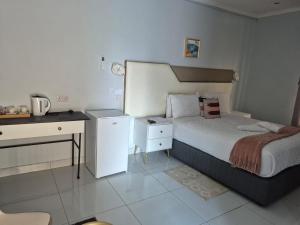 a small bedroom with a bed and a desk at Paradise Reho Guesthouse in Nata