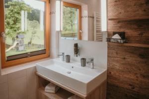 a bathroom with a white sink and a window at Landhotel Gressenbauer in Hinterstoder +170 photos