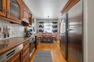 a kitchen with a stainless steel refrigerator and a table at Pyynpesä ! in Rovaniemi