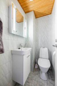 a white bathroom with a toilet and a sink at Pyynpesä ! in Rovaniemi +4 photos