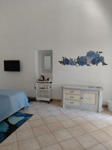 a bedroom with a bed and a desk and a television at La casa delle Camelie in Meta