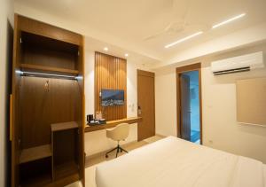 a hotel room with a bed and a desk at Sawariya Hotels in Tiruvannāmalai