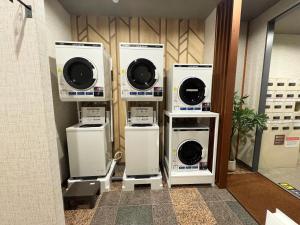 a group of washers and dryers in a bathroom at Hotel Route-Inn Isahaya Inter in Isahaya