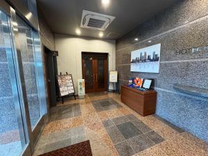 a lobby of a building with a ticket booth and a door at Hotel Route-Inn Isahaya Inter in Isahaya