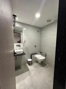 a bathroom with a sink and a toilet and a mirror at Hotel Royal Empire in Gandhinagar +35 photos